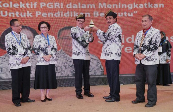 Mendagri Tjahjo Kumolo menerima cindera mata dari Gubernur Kepri Nurdin Basirun saat pembukaan Konkernas PGRI 2018 di Batam. (Foto: Istimewa)