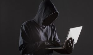 side-view-male-hacker-with-gloves-laptop